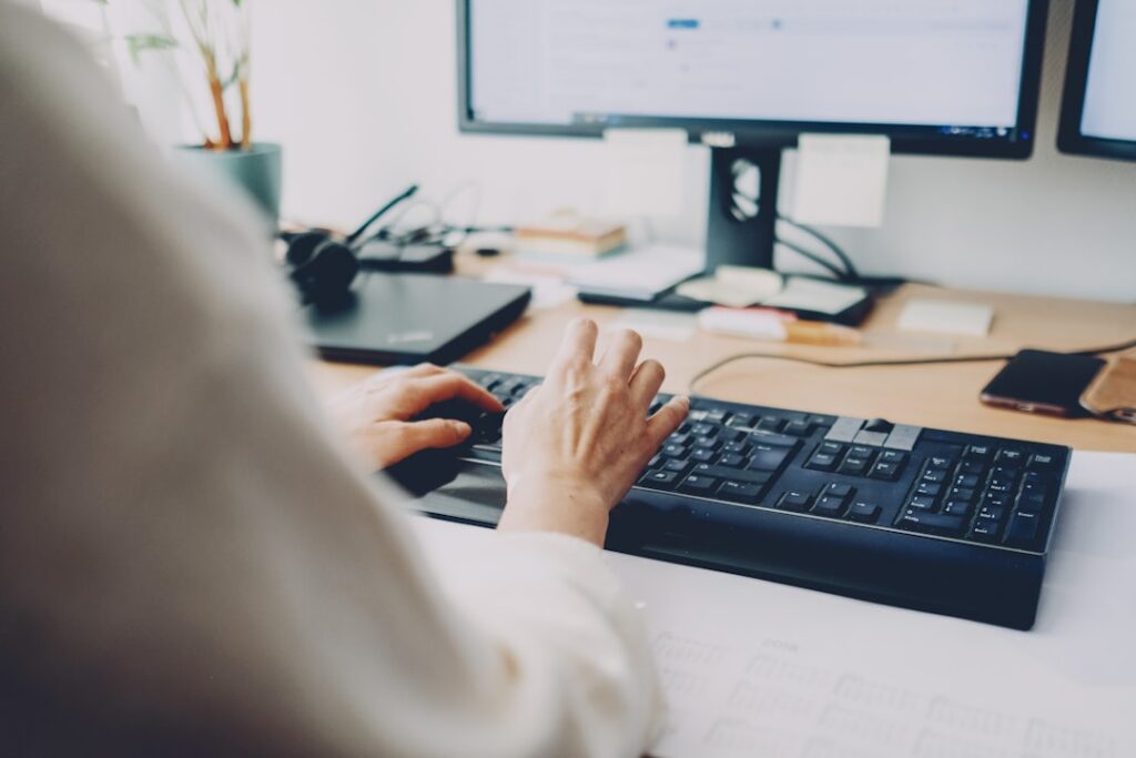 Hands using a computer keyboard representing AI-assisted work and automation